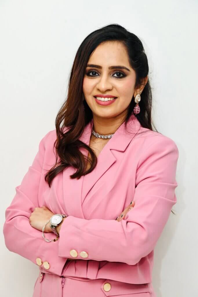 Dr. Devanshi Shah leaning against the wall with hands crossed in front